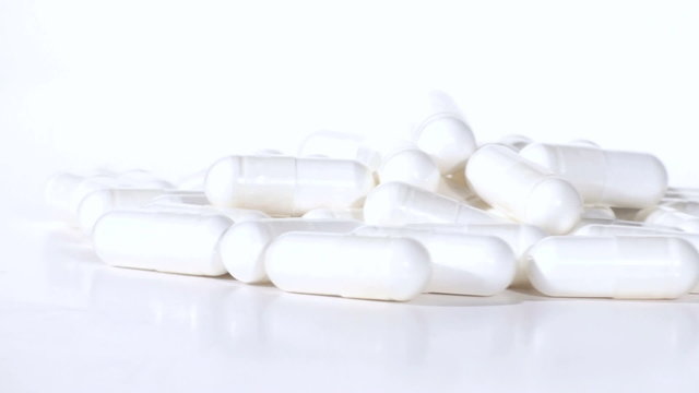 White prescription capsules zoom out from blur - HD