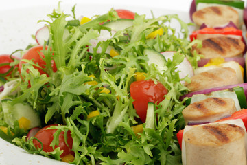 Gegrillter Bratwurstspieß an buntem Salat