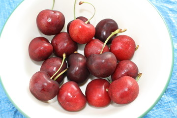 red cherries in white bowl