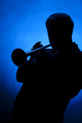 Trumpet Player Silhouette Against Blue Spot Light
