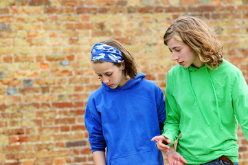 teenage girls against brick wall