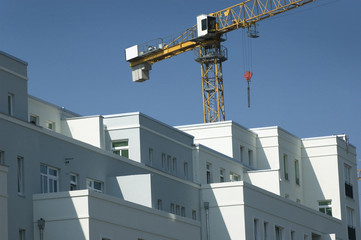 Wohnungsneubau im Sommer, Kran vor blauem Himmel