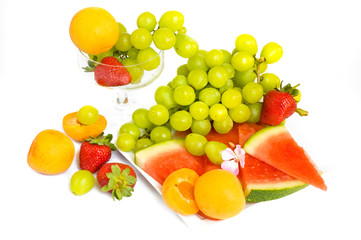Fototapeta na wymiar green grape,apricots and watermelon on a plate