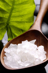 Fototapeta na wymiar Sea salt with green leaf and massage stones