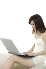 happy young woman sitting on sofa using laptop