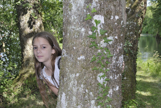 jeune fille derriere un arbre