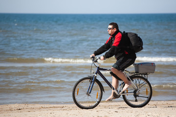 Fototapeta na wymiar man riding mountain bike on the beach