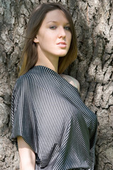 Beautiful young girl near tree