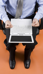 Businessman on laptop sitting in leather office chair
