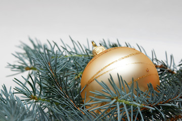 goldene weihnachtskugel mit tannenzweig