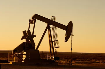 Fototapeten Funktionierende Ölpumpe im ländlichen Texas bei Sonnenuntergang © Natalia Bratslavsky