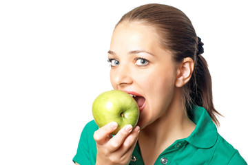 Young pretty woman in green shirt eating fresh green apple