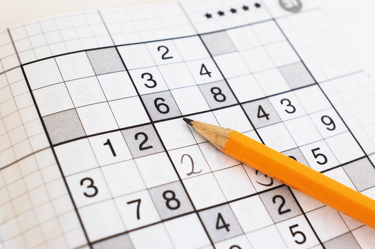 close up of sudoku game and yellow pencil