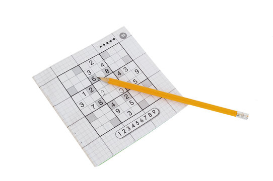 sudoku game and yellow pencil isolated on white