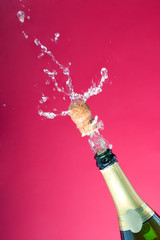 Very fine mist of champagne spraying over the cork
