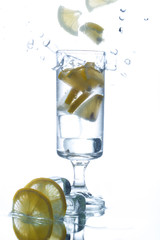 A glass of water with ice and lemon, on white background