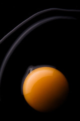 Fresh egg opened on black table