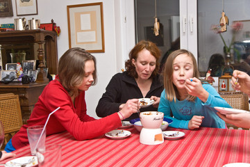 Familie freut sich beim Essen über das leckere Schokoladenfondue