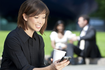 Beautiful Young Asian Woman Texting and Drinking Coffee