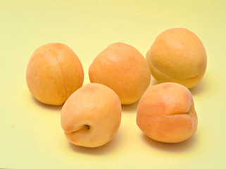 Apricots on yellow background