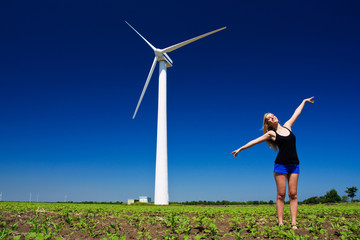 Model posing in front of wind power generator