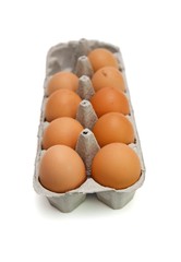 Nine brown eggs in a paper box isolated