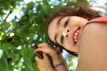 Fillette qui ramasse des cerises