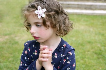 Beautiful brunette blue eyes little girl portrait on grass