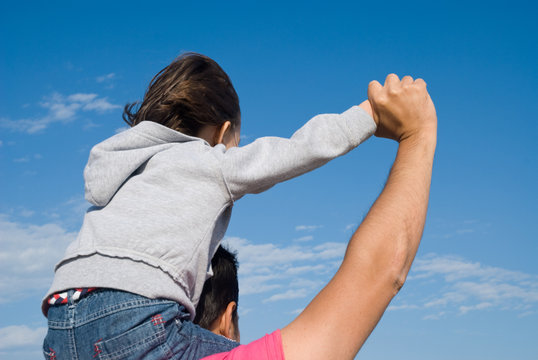 Padre e figlio guardano il cielo azzurro