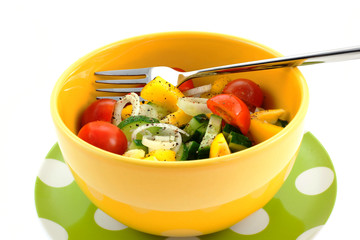 vegetable salad in a yellow bowl and fork