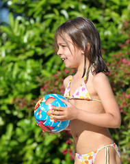 fillette tenant son ballon de plage