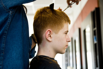 Jugendlicher mit roten langen Haaren beim Frisör