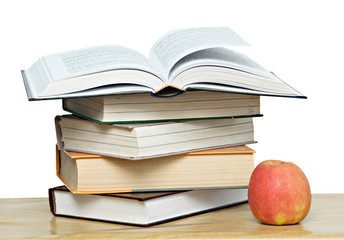 Red apple and open book on desk