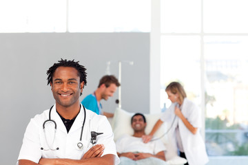 African doctor with his colleagues in the background with copy-s