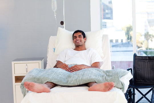 Hispanic patient in bed smiling at the camera