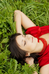 Obraz na płótnie Canvas Beautiful girl lying on the grass