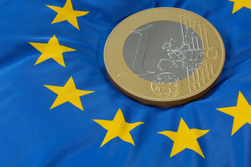 Euromünze auf Europaflagge