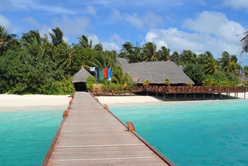 Footbridge over lagoon to a tropical island on the Maldives