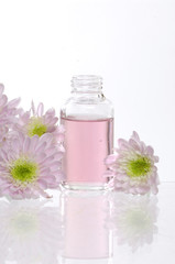 Spa bottles and daisies with reflection