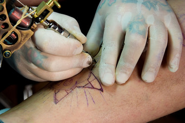 man wearing gloves and making a tattoo