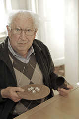 Old man playing dice