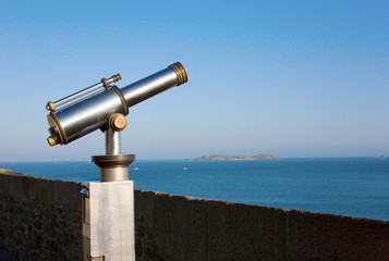 Coin operated viewfinder telescope overlooking sea shore