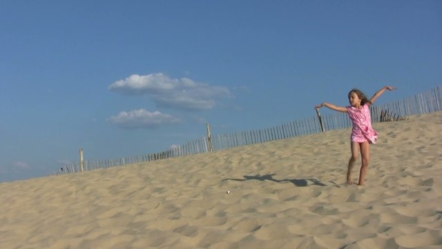 fillette dansant gracieusement au sommet de la dune