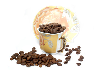 Cup with coffee beans and sauser