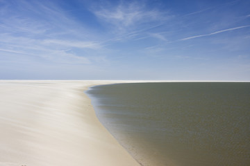 Remote part of island with cirrus clouds in blue sky.