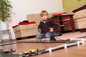 Kleiner Junge beim spielen mit Autorennbahn