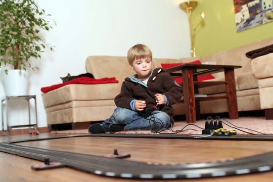 KLeiner Junge beim spielen mit Autorennbahn