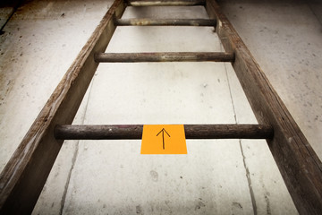 Old wooden ladder on a cement wall