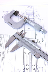 Micrometer and caliper on blueprint vertical. Shallow dof