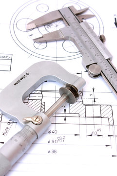 Caliper and Micrometer on blueprint vertical. Shallow dof